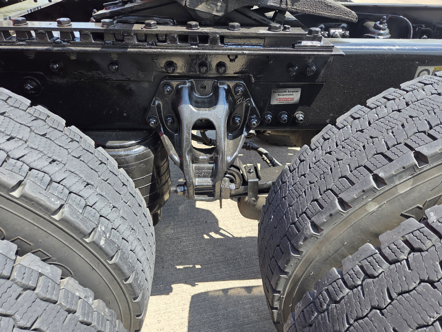 Kenworth T680 chassis showing rear drive axle or fifth-wheel area with suspension components and dual tires.