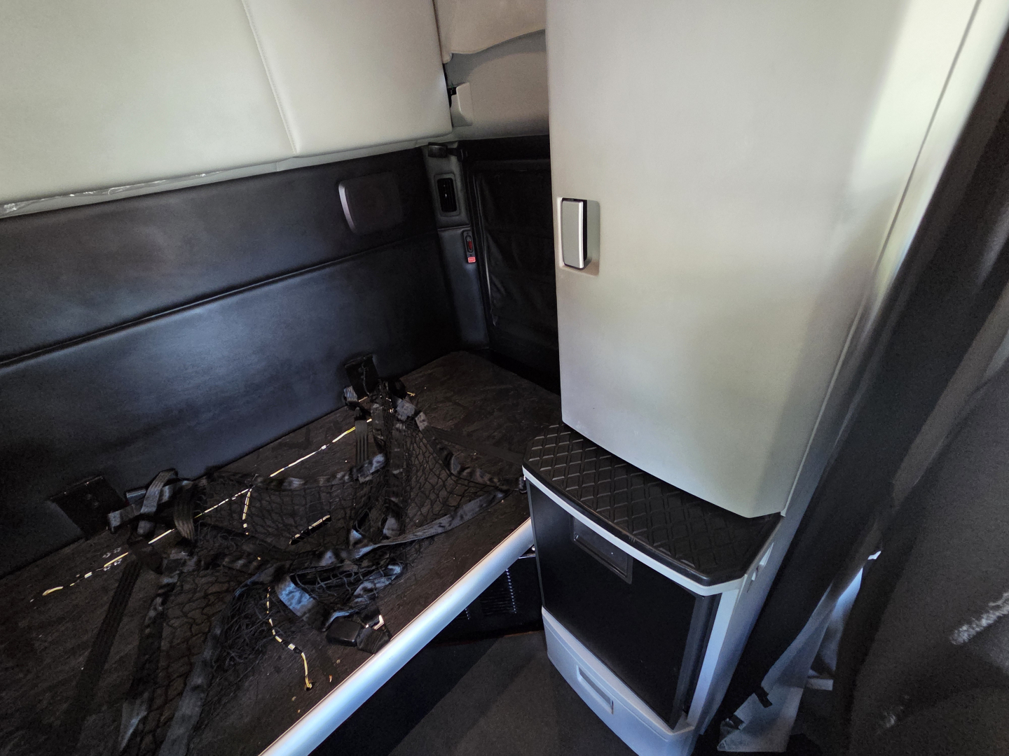 Kenworth T680 interior cab area showing sleeper berth wiring harnesses on floor and side panels with storage compartment.