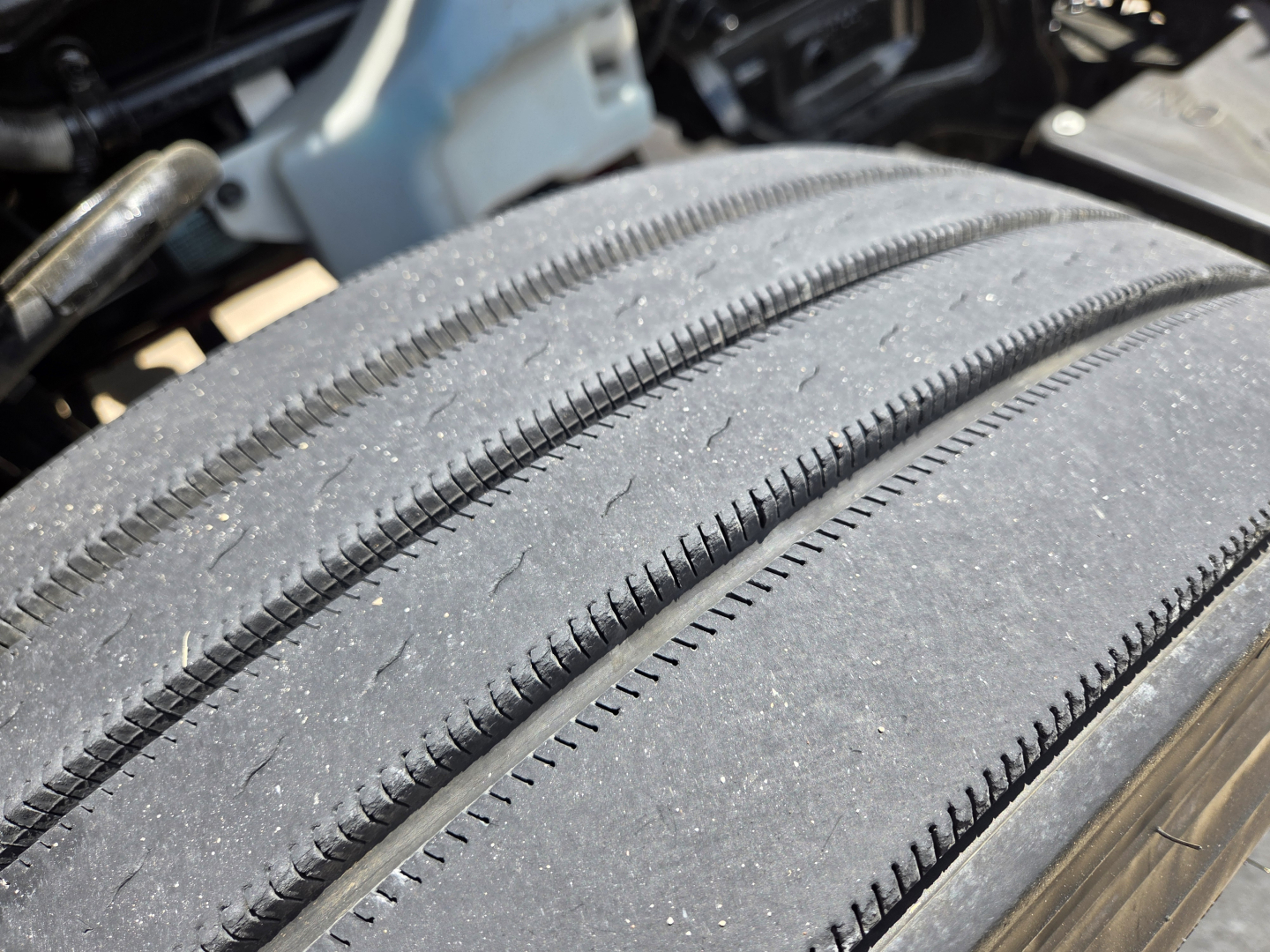 Tires of a 2023 Kenworth T680 near the wheel well, showing tread and sidewall details.