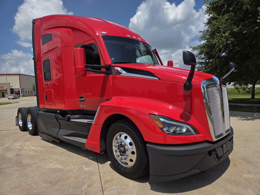 Kenworth T680 tractor in red color, front three-quarter view showing cab, grille, bumper, and wheel, no visible text or labels legible.