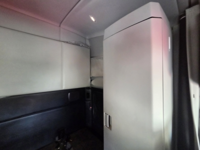 Kenworth T680 interior sleeper cab corner with storage cabinet and side panels visible.