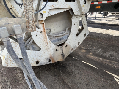 Dump trailer rear frame and underside with rust-speckled steel, wiring, and structural brackets visible.