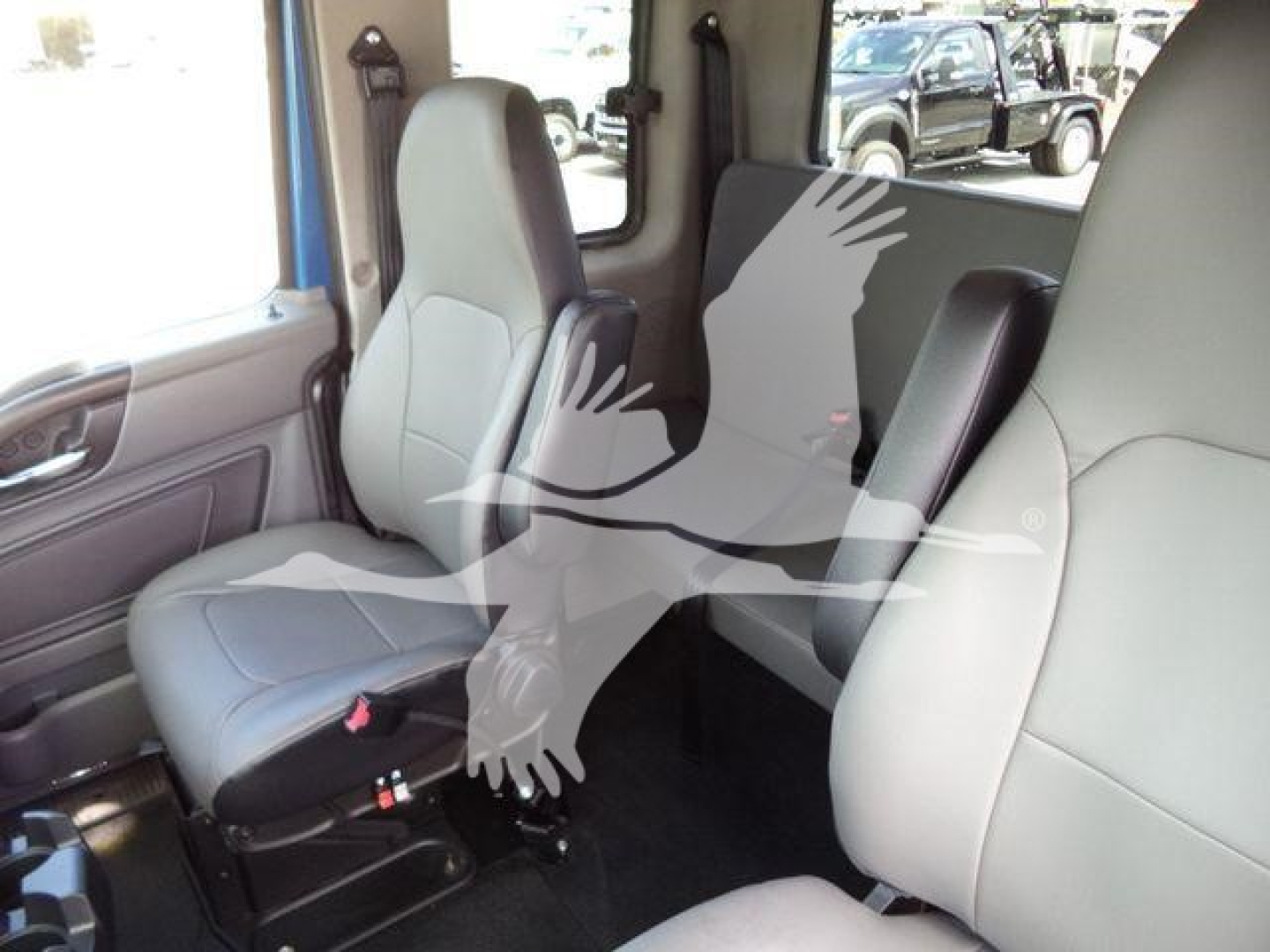 Truck cab interior showing two front seats and rear bench seat in light gray/gray upholstery.