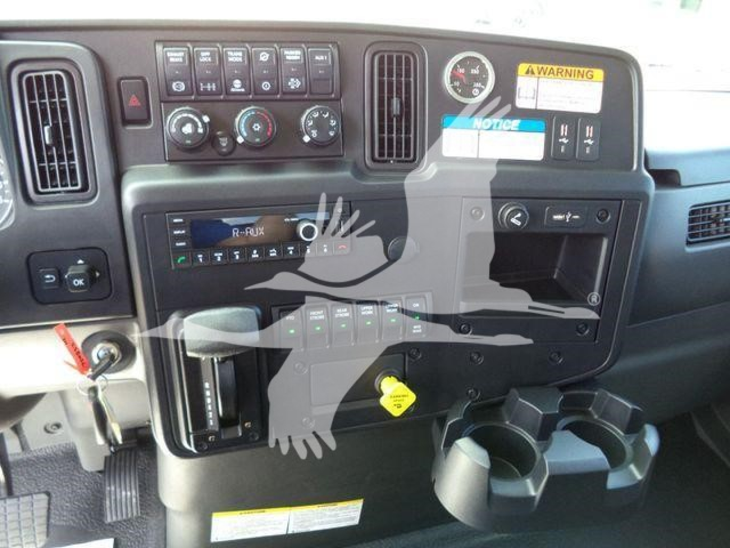 Dashboard view of a 2027 International MV rollback truck showing control panel, gauges, cup holders, and ignition area.