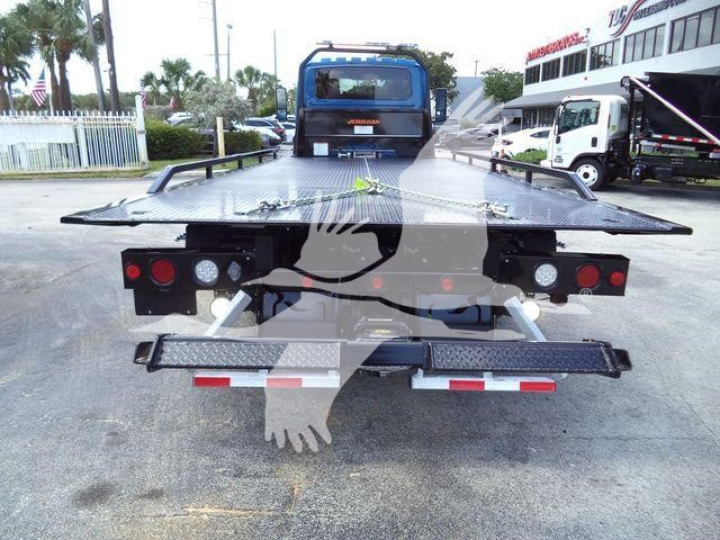 Flatbed tow truck bed with rear view showing taillights, platform, and support ramps.