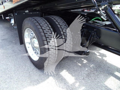 MV-series International truck undercarriage showing dual rear axles with large tread tires and suspension components.