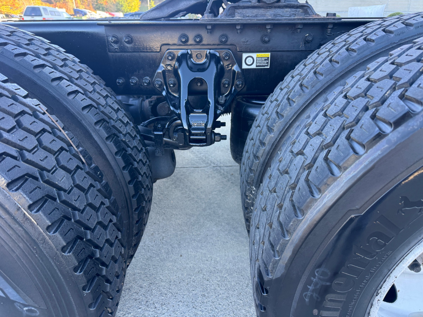 Kenworth T680 rear view showing dual rear axles and fifth wheel hitch assembly with mounting rails and frame hardware.
