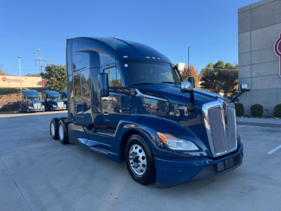 Kenworth T680 tractor-trailer cab in blue, front-right view, displaying tall sleeper and chrome grille; no visible text clearly legible on label.