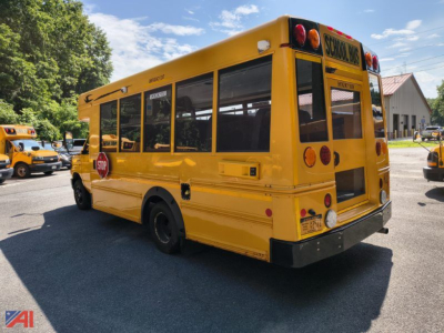 Yellow 2016 Ford E-Series school bus rear three-quarter view showing stop sign, rear lights, school bus sign, windows, and bumper.