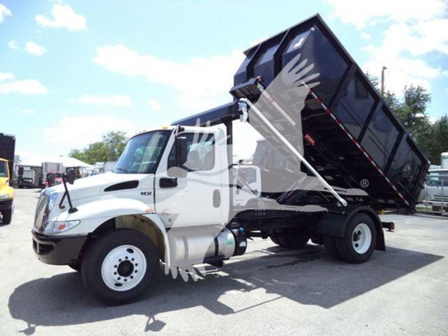Truck bed tilted dump on a white 2019 International Durastar 4300 with dump body in raised position.