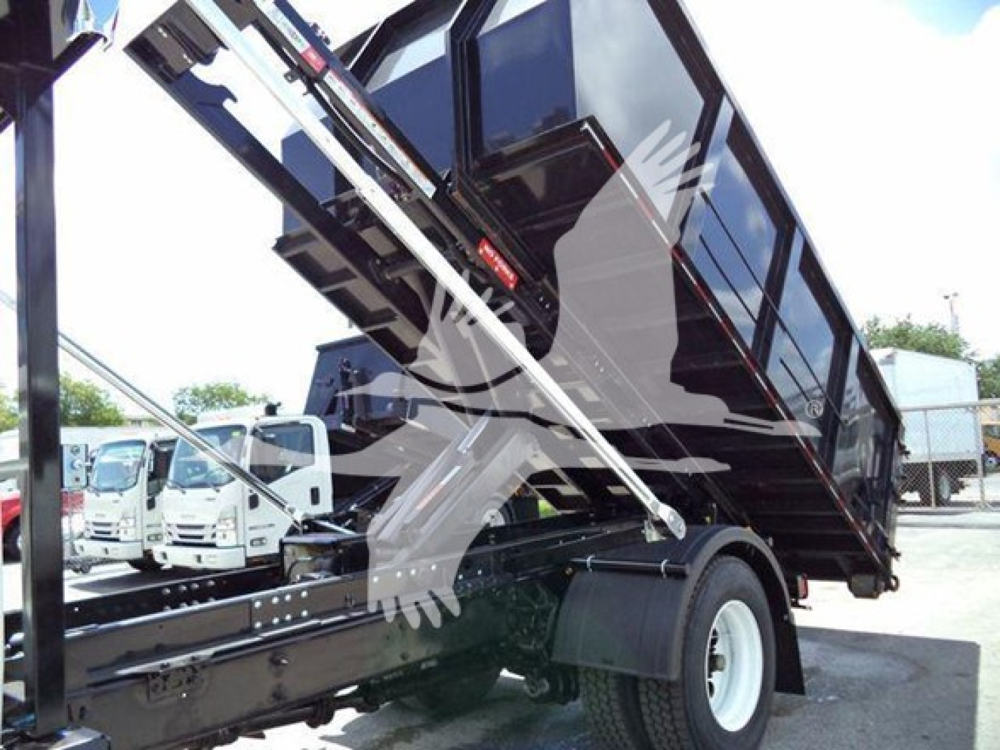 Dump truck bed in raised position on a 2019 International Durastar 4300 roll-off truck showing hydraulic arms and rear wheel.”