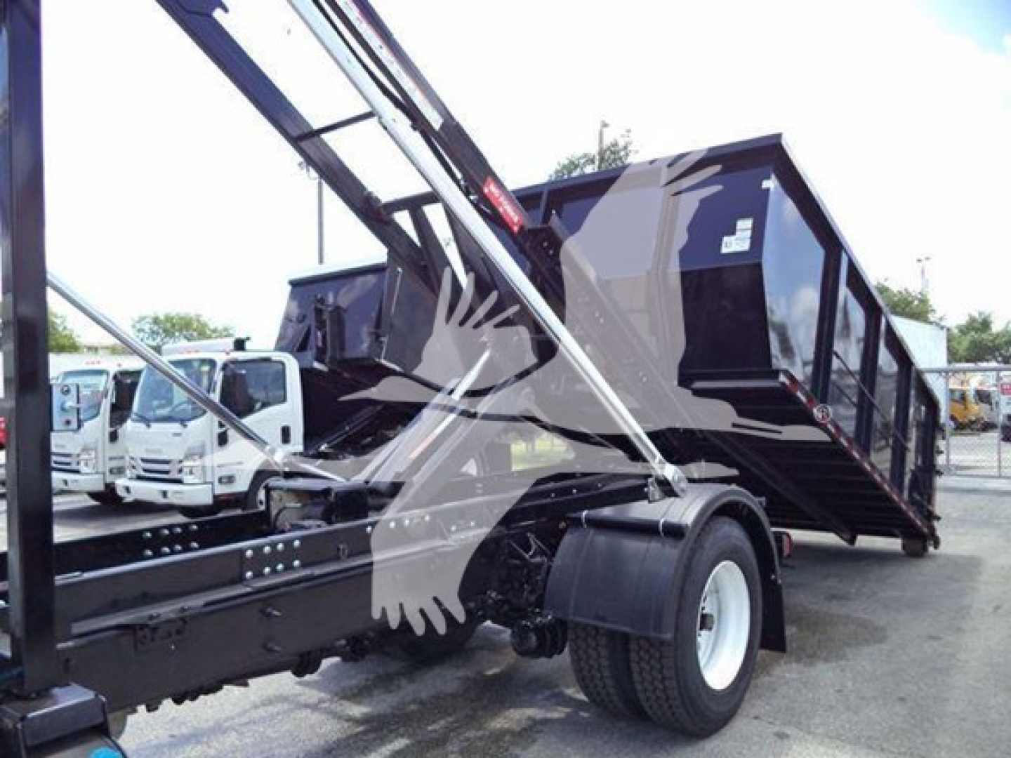 Truck: 2019 International Durastar 4300 roll-off with crane arm and black dump body, side view showing wheel, chassis, and hydraulic components.