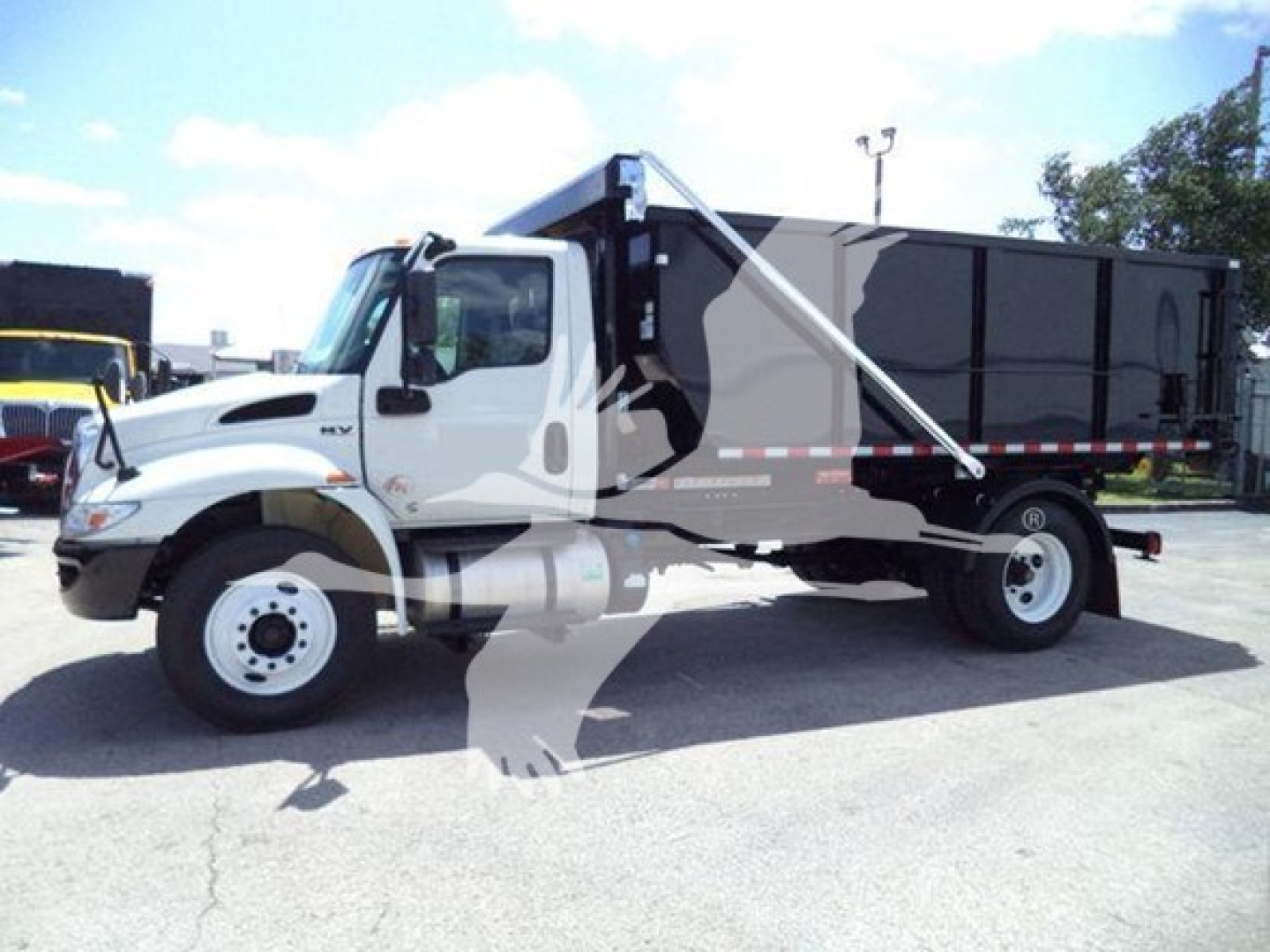 2019 International Durastar 4300 roll-off truck in side view with cab and dumping container. Visible text includes model 4300 badge and International logo.