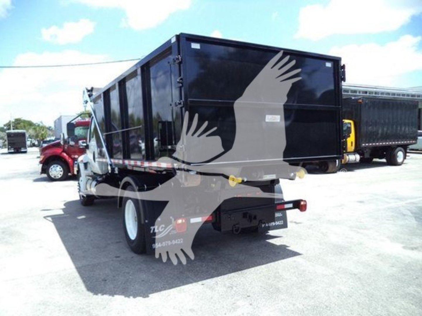 Truck bed rear view showing dump bed and taillights on International Durastar 4300 roll-off with black container and white wheels.