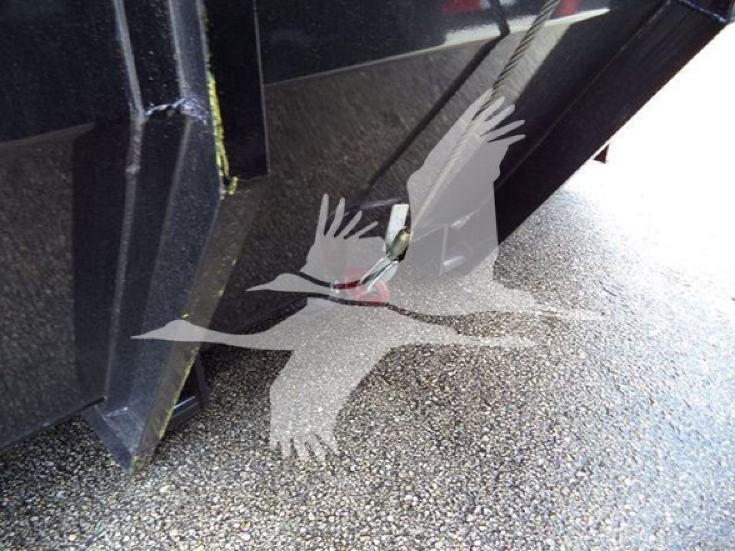 Truck bed/hoist area of a 2019 International Durastar 4300 roll-off showing metal structure and ground texture.