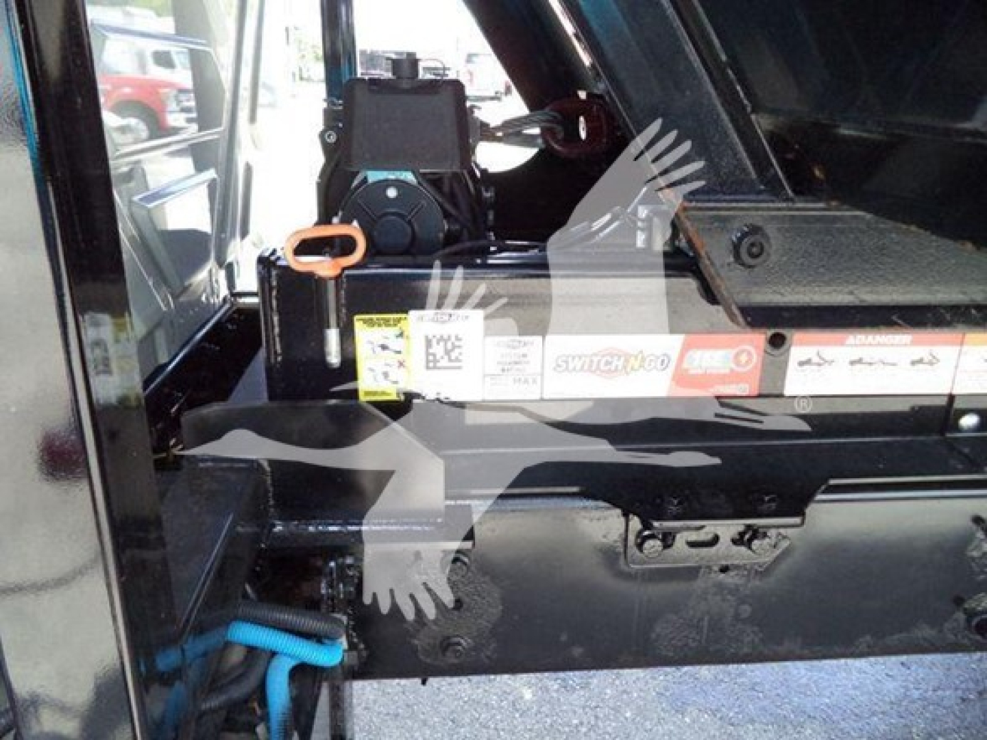 Trucks showing interior of roll-off body with control lever and labels visible