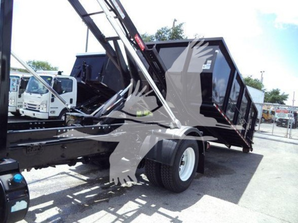 Truck bed and dump body in elevated position on International Durastar 4300 roll-off truck showing hydraulic arm and dual rear wheels.