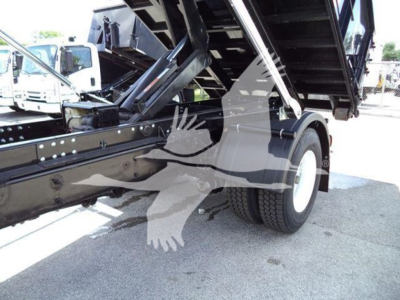Truck bed area of a 2019 International Durastar 4300 roll-off showing hydraulic bed and rear wheel.