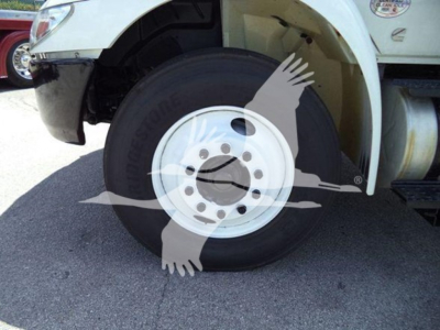 Wheel and front fender of a 2019 International Durastar 4300 rolloff truck showing front wheel and bumper area.