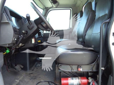 Truck cab interior showing steering wheel and driver's seat of a 2019 International Durastar 4300 rolloff truck.