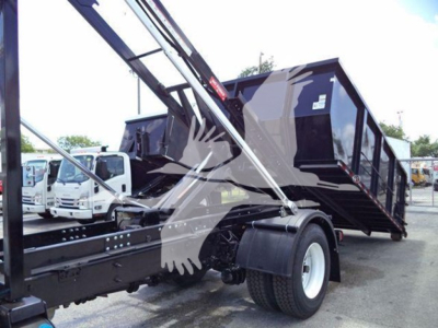 Truck: 2019 International Durastar 4300 roll-off with crane arm and black dump body, side view showing wheel, chassis, and hydraulic components.