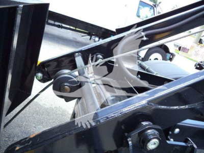 Engine bay or hitch area of a 2019 International Durastar 4300 roll-off truck showing hydraulic arm and mounting brackets.