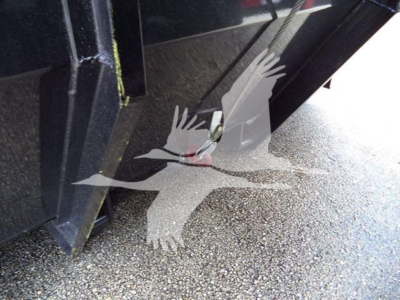 Truck bed/hoist area of a 2019 International Durastar 4300 roll-off showing metal structure and ground texture.