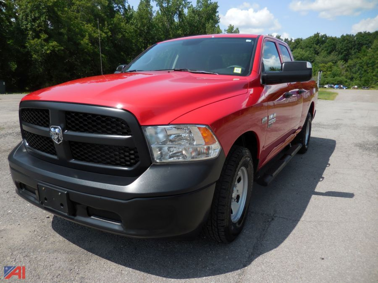 Ram 1500 pickup truck in red with black grille and front bumper, Quad Cab, 4x4, parked in outdoor lot.