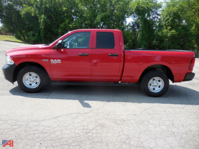 Ram 1500 pickup truck side view showing Crew Cab with Quad Doors red exterior, dual front doors, long bed, RAM 1500 badge on front fender.