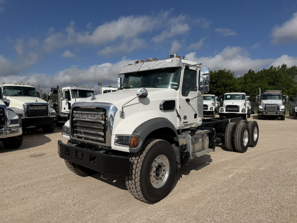 Mack GR64F cab and chassis truck in a dealership lot with other trucks in background.