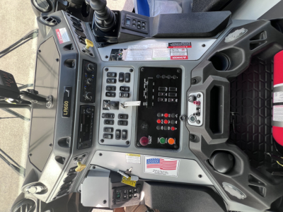 Mack LR64 console showing control panel with switches, gauges, and digital display; visible labels and switches in operator cockpit.
