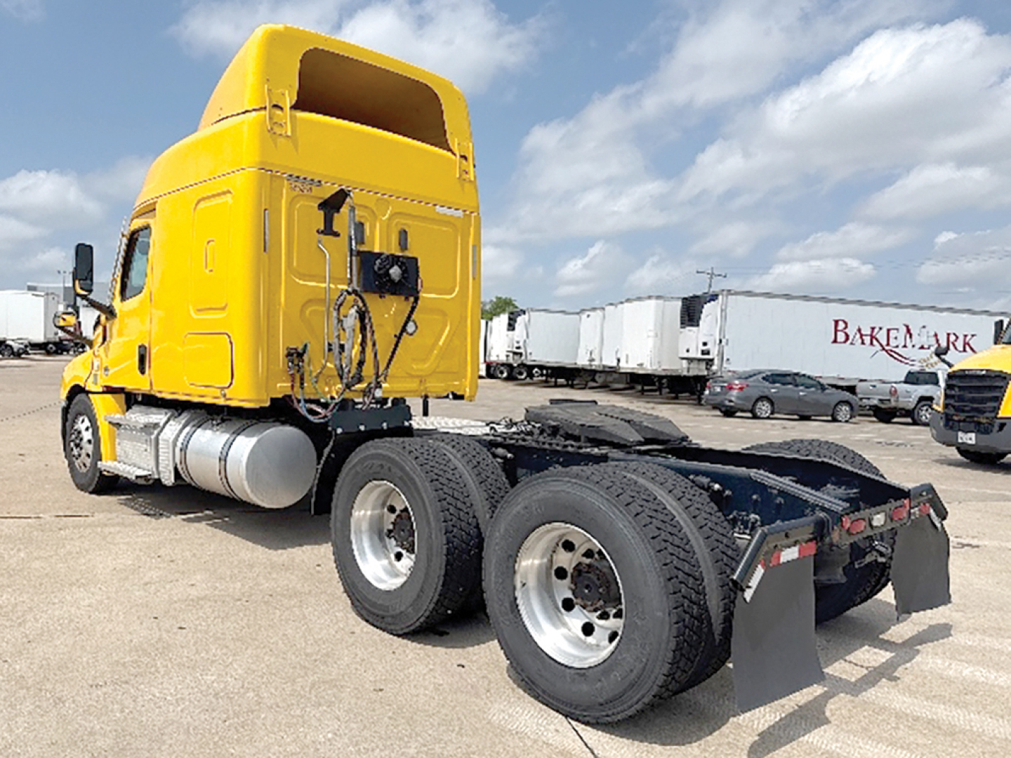 Freightliner Cascadia126 tractor tractor rear view showing dual rear axles and fifth-wheel plate with malleable connections.