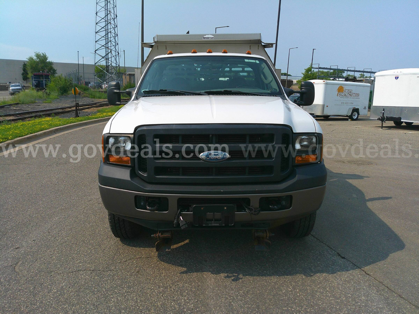 Ford F-350 dump truck front view showing black grille, headlights, and bumper with hitch receiver.