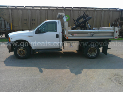 Ford F-350 dump truck side view showing utility bed and crane attachment.