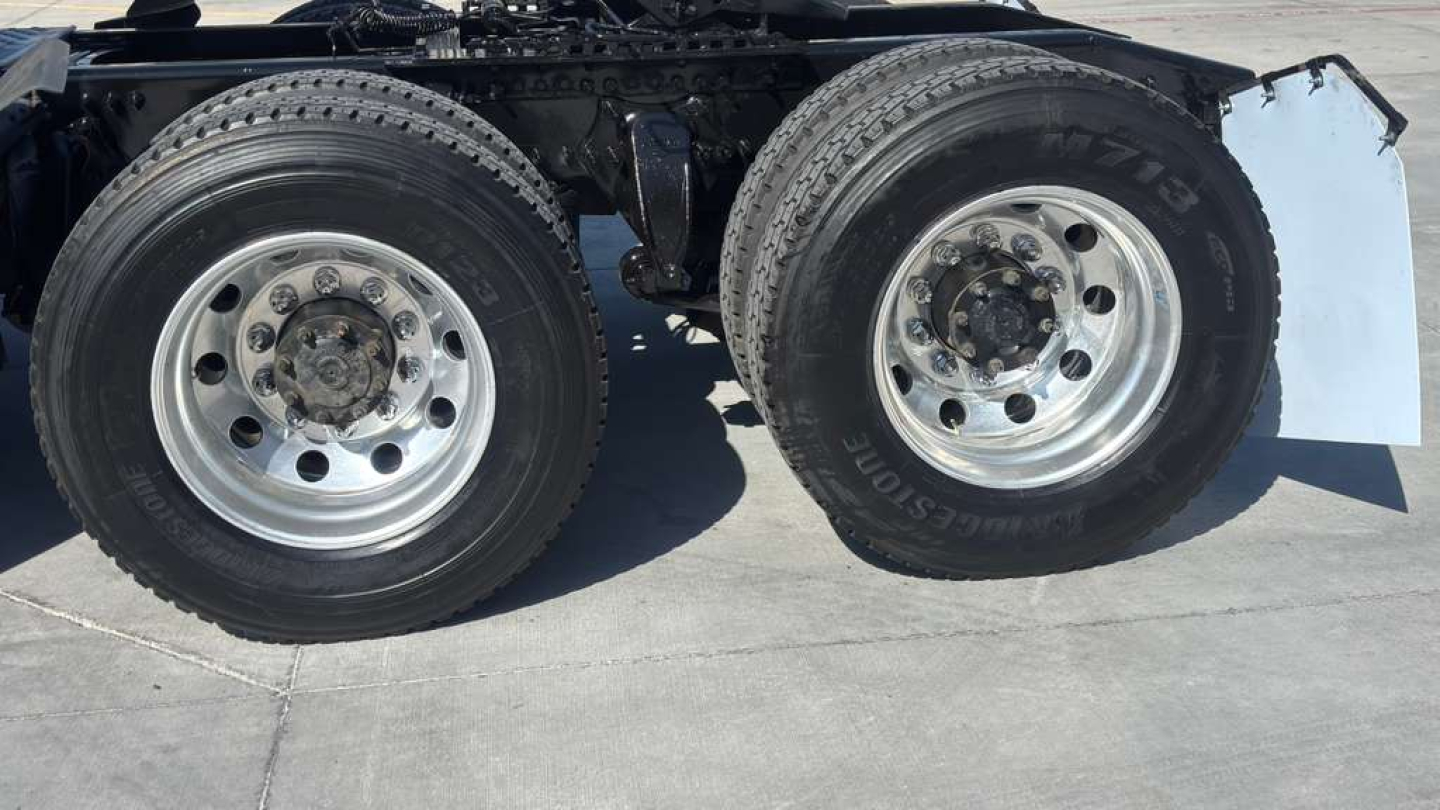 Dual rear wheel assembly of a Freightliner truck showing dual aluminum rims and tires