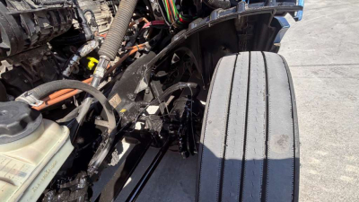 Truck engine bay showing maintenance components and wiring harness near cooling reservoir and air intake for Freightliner PT126064ST.