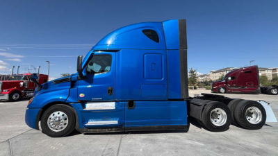 Freightliner PT126064ST truck side profile showing blue cab and sleeper, tandem rear axles, chrome steps, and black chassis.