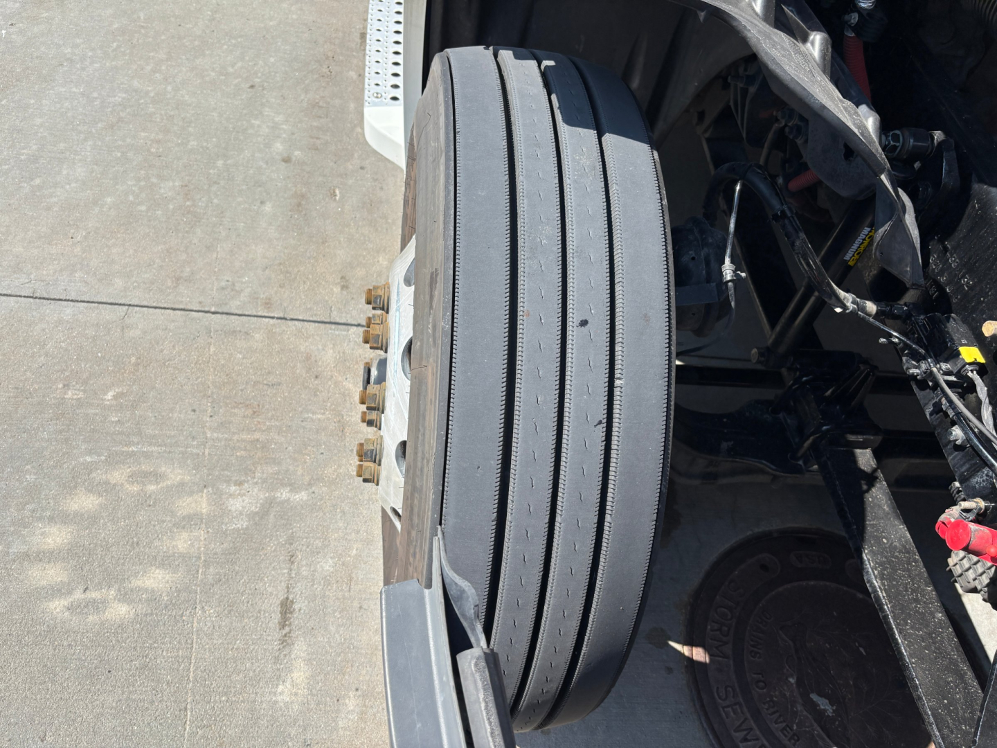 Truck wheel on Freightliner PT126064ST chassis showing dual rear axles and exposed drivetrain components.