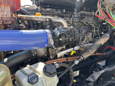  Freightliner PT126064ST engine bay showing multiple hoses and a blue silicone intercooler pipe clamp, view of radiator-side components and label stickers.