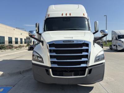 Front view of a white Freightliner PT126064ST truck showing the grille, headlights, and bumper. Tableau has a small badge in the center and license-like plate area.