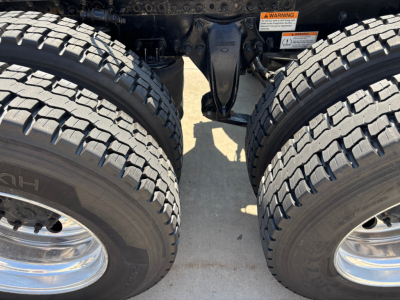 Dual rear trucks wheels and suspension of a Freightliner PT126064ST tractor showing twin tires and rear axle area with exposed chassis components.