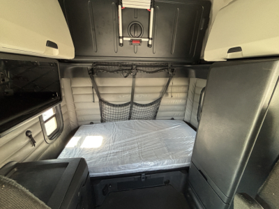 Freightliner PT126064ST sleeper cab interior showing bunk bed with mattress and overhead storage.
