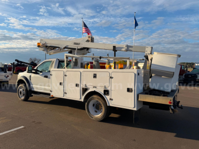 Ford F-550 utility bucket truck with bucket lift extended, service bodies with compartments, truck bed toolbox, rear outriggers, and label panels.