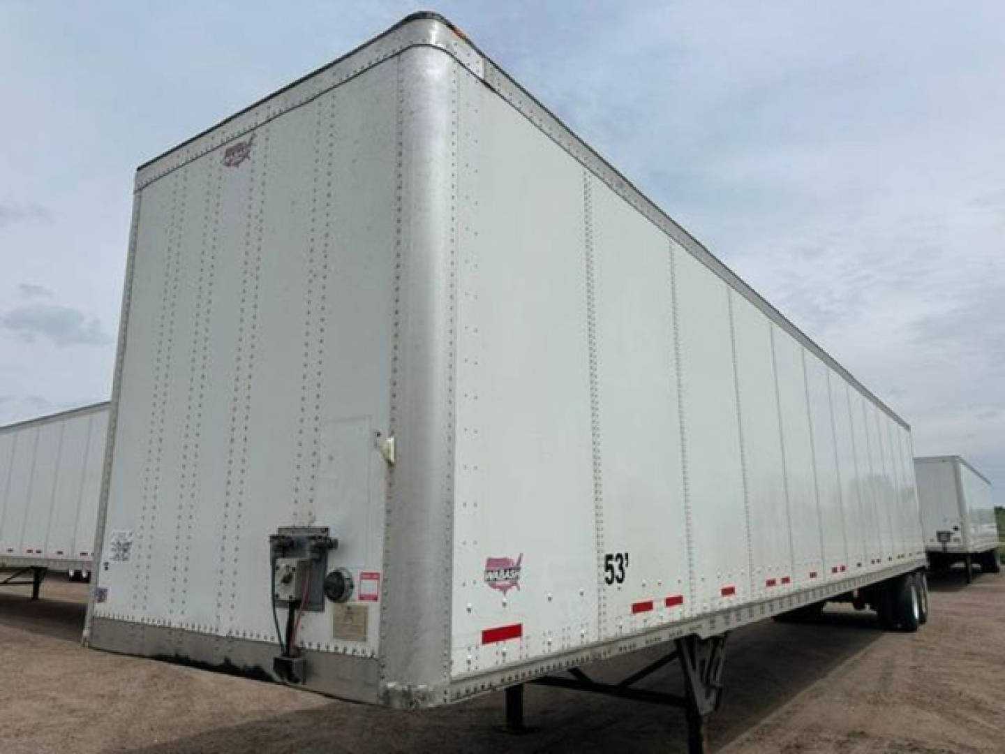 Trailer side and front showing 53' aluminum box trailer with hitch, wheels, and rear doors; VIN tag and stock number pictured.