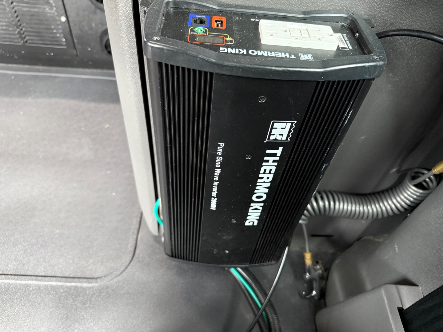 Thermoking auxiliary power unit/IDL inverter mounted in a truck cab showing label and connection ports.