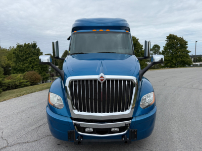 Front view of a blue 2024 International LT625 conventional sleeper truck showing chrome grille, bumper, and dual side mirrors.