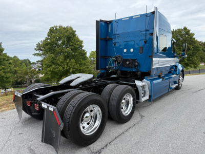 Truck chassis and rear cab of a blue 2024 International LT625 sleeper tractor showing dual rear axles and fifth wheel hitch.