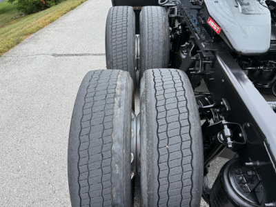 Truck rear axle dual tires with tread visible on International LT625 chassis, chassis frame and suspension components in view.