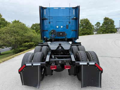 Truck rear view of a blue 2024 International LT625 tractor with dual rear axles and mud flaps, showing fifth wheel area and chassis.