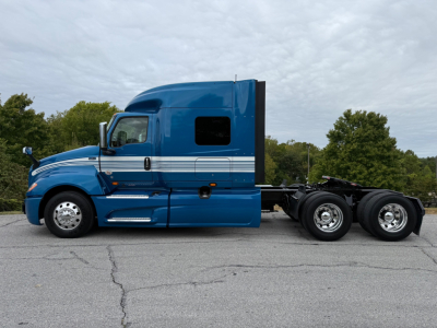 2024 International LT625 tractor-trailer side view showing blue sleeper cab with chrome steps and dual rear axles.